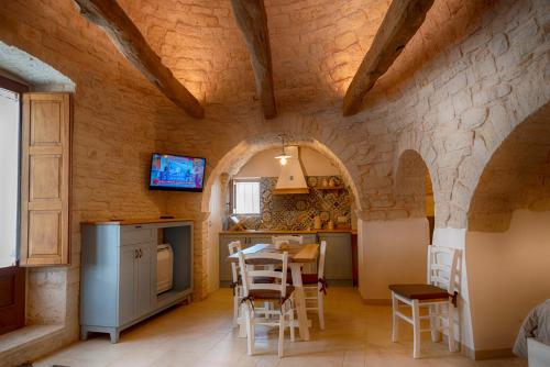 a kitchen with a table and chairs in a room at Trullo Dell'Erba in Alberobello