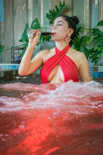 a woman in a bathtub drinking a glass of wine at Hotel Hacienda Santa Clara in Santa Rosa de Cabal