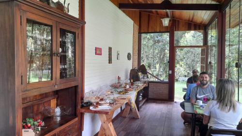 a group of people sitting at a table in a restaurant at Pousada Bosque do Visconde in Visconde De Maua