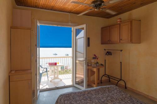 1 dormitorio con puerta que da a un balcón con vistas al océano en Le Surplage, en Hyères