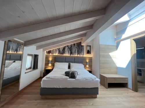 a bedroom with a large bed and a wooden ceiling at Le Rocce Val di Non - Quality Room & Breakfast in Tassullo