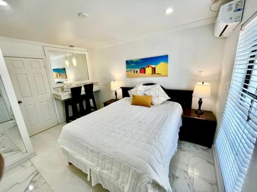 a bedroom with a white bed and a bathroom at Colony Club Inn & Suites in Nassau