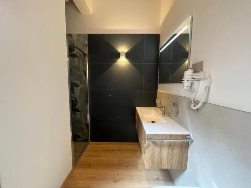 a bathroom with a sink and a shower at Le Rocce Val di Non - Quality Room & Breakfast in Tassullo