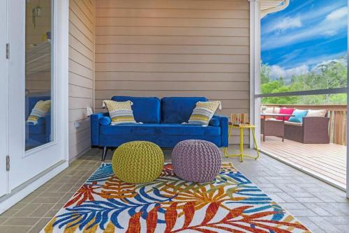 un porche con sofá azul y 2 sillas sobre una alfombra en Cozy Home on the outskirts of Tallahassee, en Tallahassee