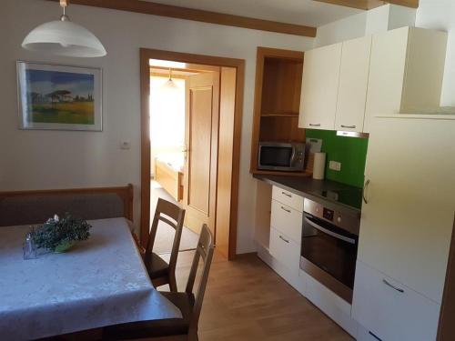 a kitchen with a table and a kitchen with a refrigerator at Haus Meikl in Mühlbach am Hochkönig