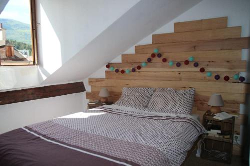 een slaapkamer met een groot bed met een houten hoofdeinde bij Appartement de caractère in Gap