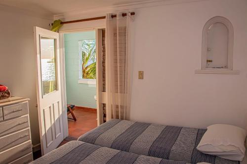 1 dormitorio con 1 cama, vestidor y ventana en Sunrise at Point Village-Negril, en Negril