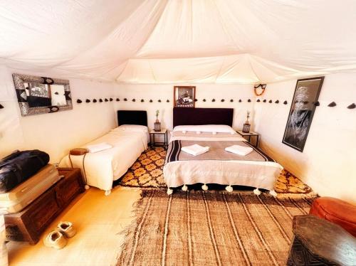 a bedroom with two beds in a tent at Kasbah Erg Chebbi in Merzouga