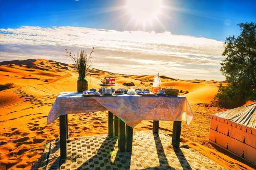 a table in the desert with food on it at Kasbah Erg Chebbi in Merzouga