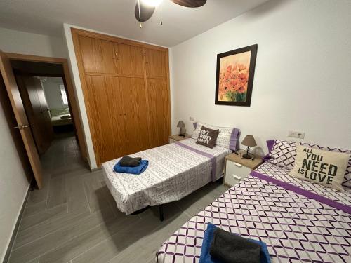 a small bedroom with two beds and a door at Gran apartamento céntrico y muy cerca de la playa in Fuengirola