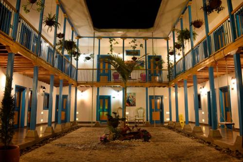 a hallway of a building with blue and yellow doors at Hotel Hacienda Santa Clara in Santa Rosa de Cabal