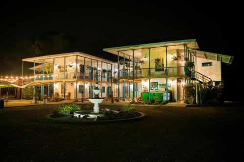 a large building with a fountain in front of it at night at Hotel Hacienda Santa Clara in Santa Rosa de Cabal