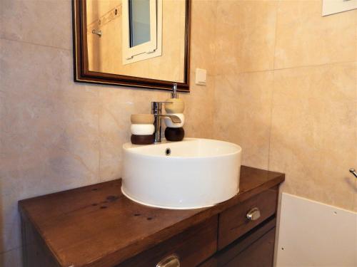 W łazience znajduje się biała umywalka i lustro. w obiekcie Villa Evridiki w mieście Georgioupolis