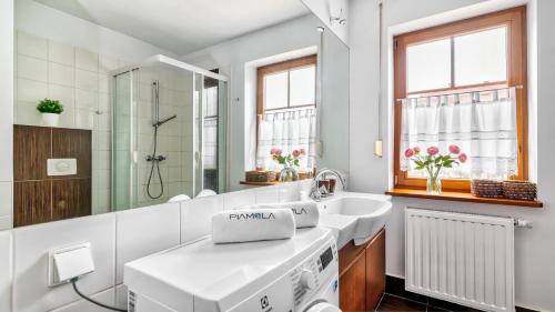 a white bathroom with a sink and a mirror at Apartamenty PIAMOLA Willa Turkusowa in Kąty Rybackie