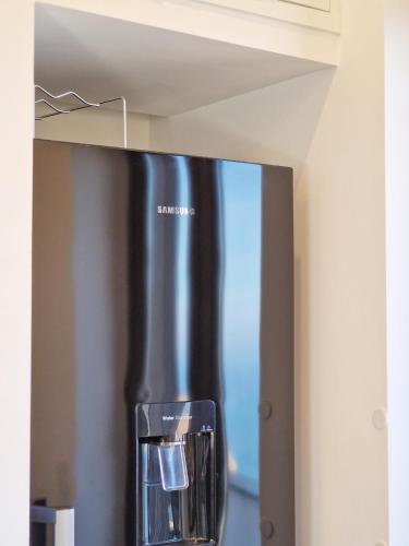 a black refrigerator in a kitchen with a window at Maison Danielle in Vico Equense