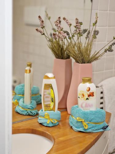 a bathroom counter with a sink and towels and flowers at Maison Danielle in Vico Equense