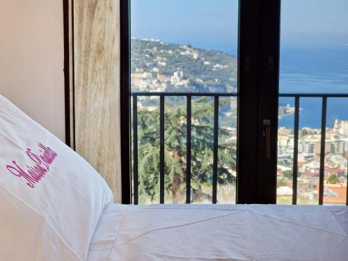 a bedroom with a bed with a view of a city at Maison Danielle in Vico Equense