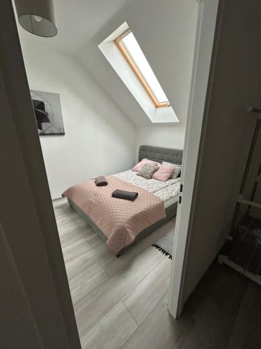 a bedroom with a bed with pink pillows on it at Koniec Świata Stare Sady apartament in Mikołajki