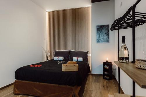 una camera da letto con un letto con un piumone nero di Vittoria Suite a Campobasso