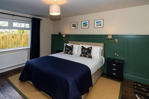 een slaapkamer met een bed met blauwe en groene muren bij The Halt @ The Halfway House Country Pub in The Sheddings