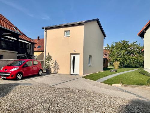 a red car parked in front of a house at Gite Au sauna de l’Aubach in Scherwiller