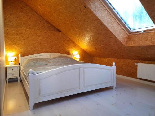um quarto com uma cama branca num sótão em Nad stawem em Mrągowo