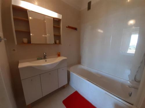 ein Badezimmer mit einem Waschbecken, einer Badewanne, einem Waschbecken und einem Spiegel in der Unterkunft Le Renoir in Cannes