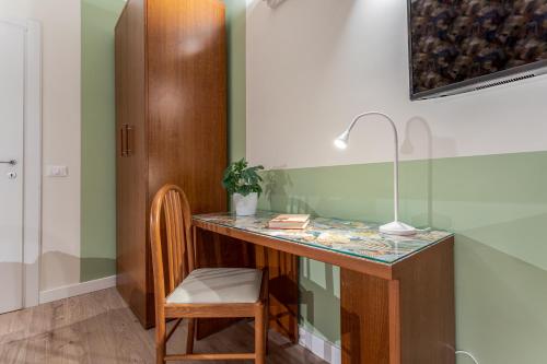 a desk with a lamp and a chair in a room at Vittoria Garden Suites in Rome