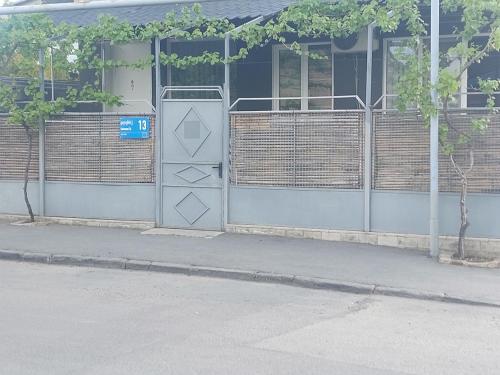 a building with a gate in front of a street at Sweet home in Tbilisi City