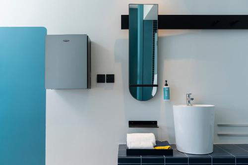 a bathroom with a sink and a mirror at GO Hotel Ban Chang at Robinson Lifestyle Ban Chang in Ban Chang