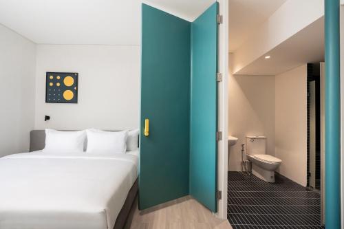 um quarto com uma cama e uma casa de banho com um WC em GO! Hotel Ban Chang at Robinson Lifestyle Ban Chang em Ban Chang