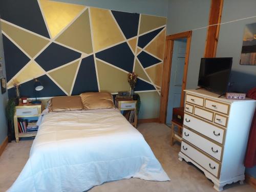 a bedroom with a bed and a tv and a dresser at Cowgirl Palace in Sag Harbor