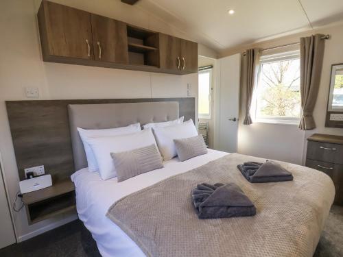 a bedroom with a large bed with two towels on it at Foxglove Lodge in Saltburn-by-the-Sea