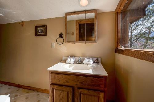加特林堡的住宿－Bearway to Heaven，一间带水槽和镜子的浴室以及窗户。
