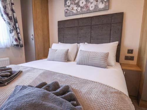a bedroom with a large white bed with two towels on it at Tulip Lodge in Saltburn-by-the-Sea
