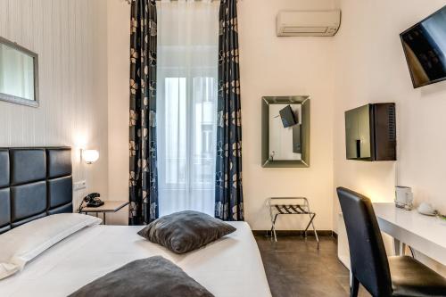 ein Schlafzimmer mit Bett, Schreibtisch und Fenster in der Unterkunft Deko Rome in Rom