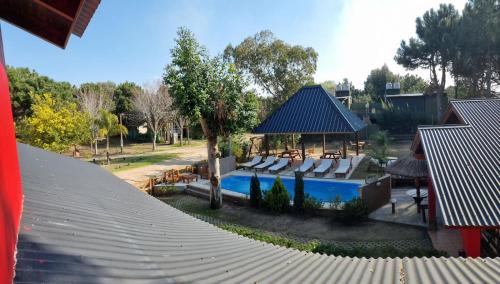 - une piscine avec des chaises et un pavillon dans l'établissement Complejo Cabañas del Jaguel, à Santa Teresita