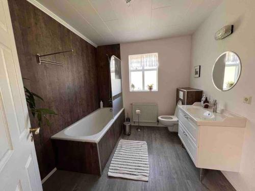 a bathroom with a tub and a toilet and a sink at Nýlenda in Seyðisfjörður