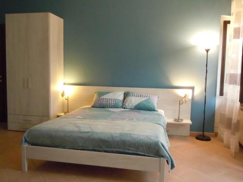 a bedroom with a large bed with blue walls at La casa di Marigio' in Tronzano Vercellese
