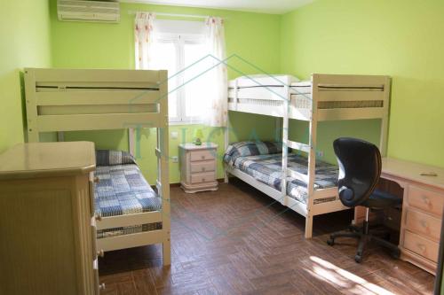 a room with two bunk beds and a desk at Villa Zahara de 3 habitaciones con Piscina in Cádiz