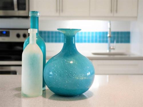 two blue glass vases sitting on a counter in a kitchen at Sunset Cove # 303 in West Bay