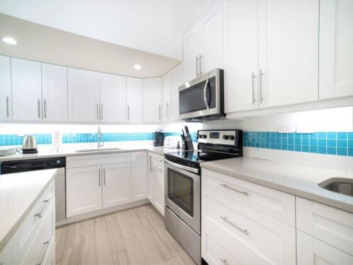 a white kitchen with white cabinets and appliances at Sunset Cove # 303 in West Bay