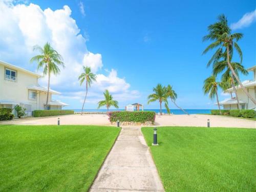 a pathway leading to a beach with palm trees at Sunset Cove # 303 in West Bay