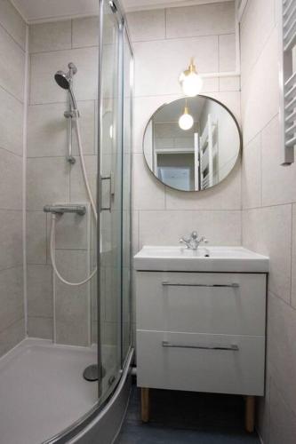 une salle de bain avec une douche, un lavabo et un miroir dans l'établissement Dreamtime - Jardin plein sud & proche commerces, à Courseulles-sur-Mer