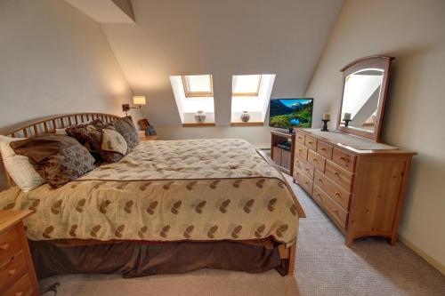 een slaapkamer met een bed, een dressoir en een spiegel bij Pines 2129 in Keystone