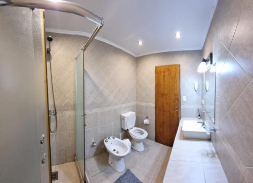 La salle de bains est pourvue de toilettes, d'un lavabo et d'une douche. dans l'établissement Complejo Cabañas del Jaguel, à Santa Teresita