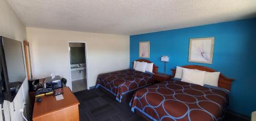 ein Hotelzimmer mit 2 Betten und einem Schreibtisch in der Unterkunft American Inn Motel in Pratt