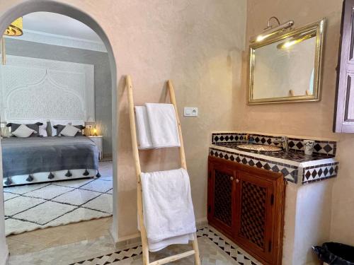a bathroom with a sink and a bed and a mirror at Riad Jolie in Marrakesh