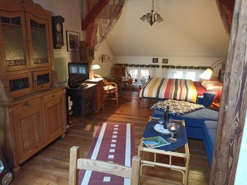 a living room with a blue couch and a tv at Anno-Nostalgia in Rheinsberg