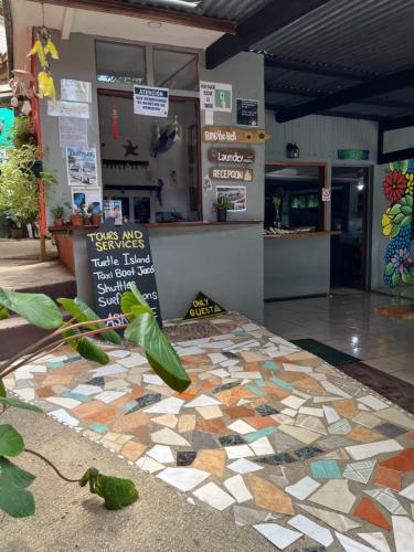 a restaurant with a tiled floor in front of a building at Pura Vida Hostel in Montezuma